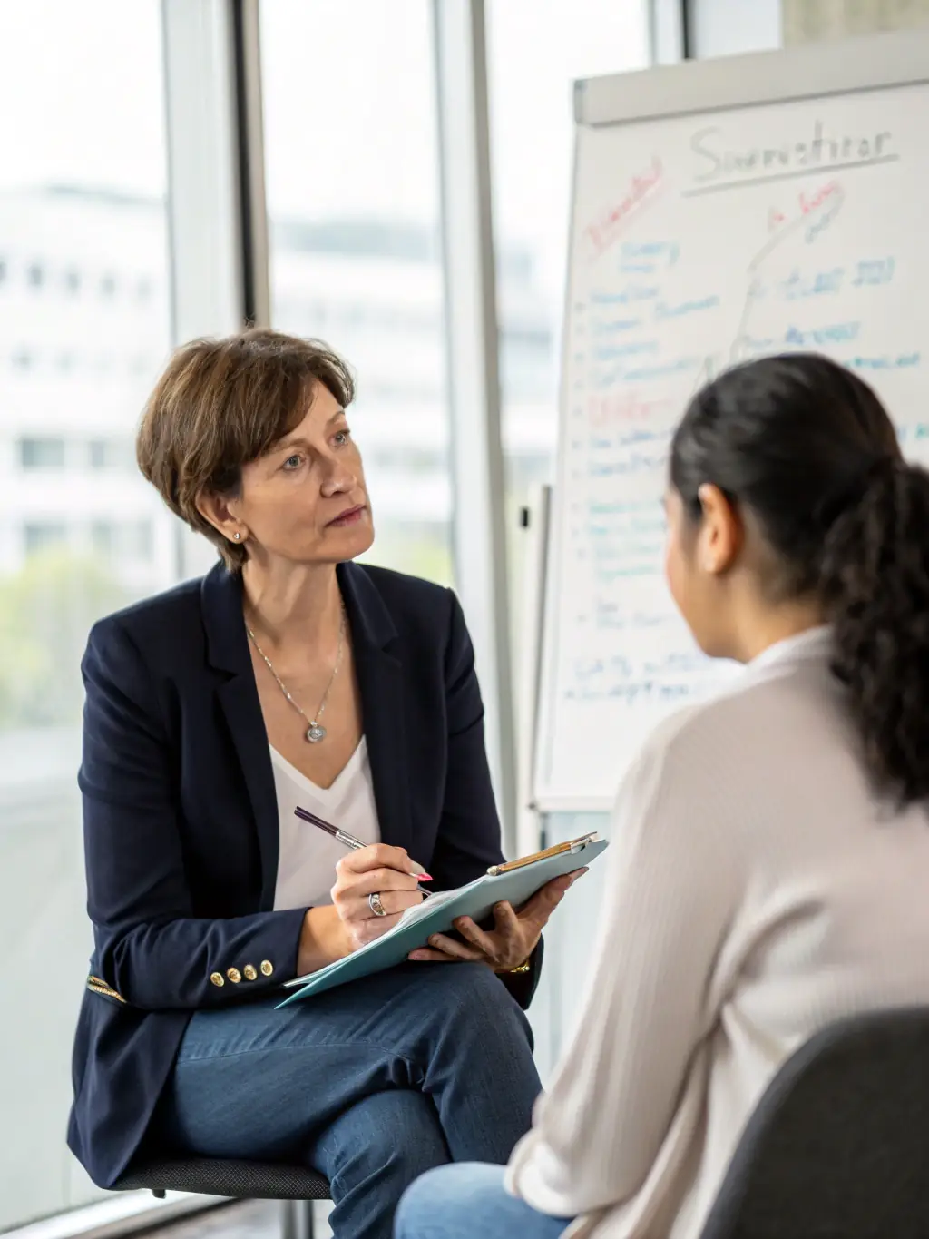 A coach providing one-on-one guidance to a business leader, focusing on emotional intelligence and self-awareness, in a quiet and professional office setting in Edinburgh.